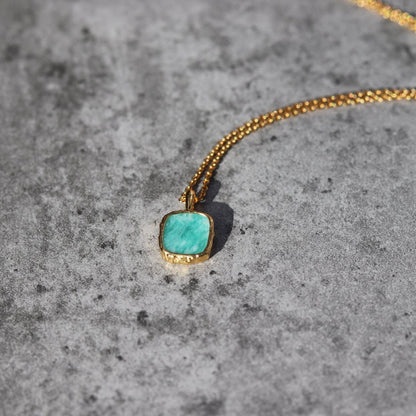 Photo of amazonite blue stone gold plated necklace on a grey marble effect background.