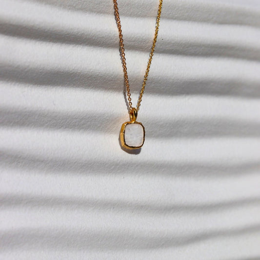 Photo of white stone gold plated necklace on a white background.