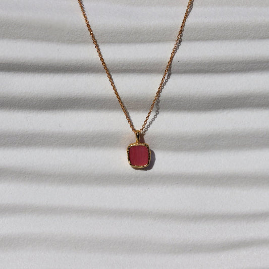 Photo of red stone gold plated necklace on a white background.